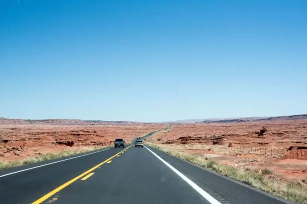 A highway road through a red-sand desert in Utah