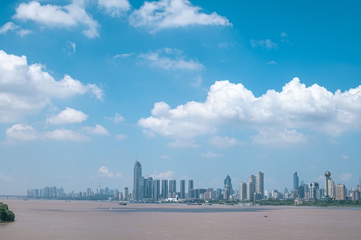 Beautiful cityscape with skyscrapers and modern buildings on a coastline on summer day under blue cloudy sky