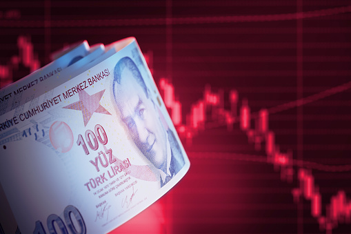 Concepto financiero - 100 billetes de liras turcas sobre gráfico de barras rojas photo