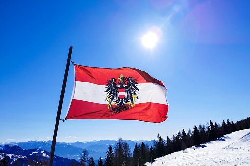 Austrian National Flag waving in the wind in a skiing area