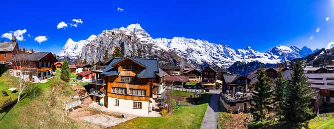 Switzerland nature and travel. Alpine scenery. Scenic traditional mountain village Murren surrounded by snow peaks of Alps. Popular tourist destination and ski resort