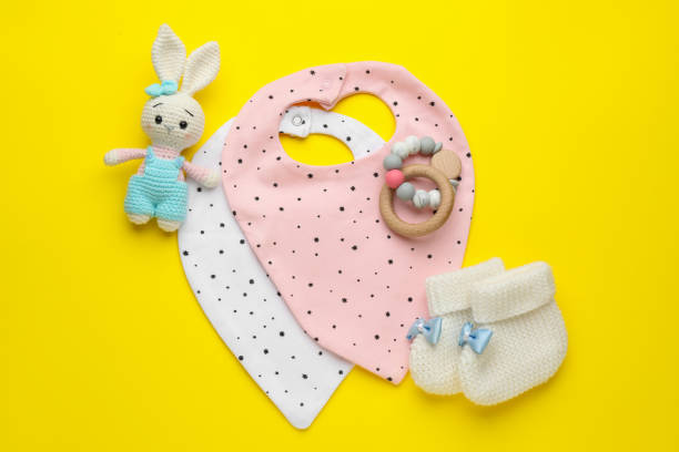 istock Flat lay composition with drool baby bibs and accessories on yellow background 1433104270