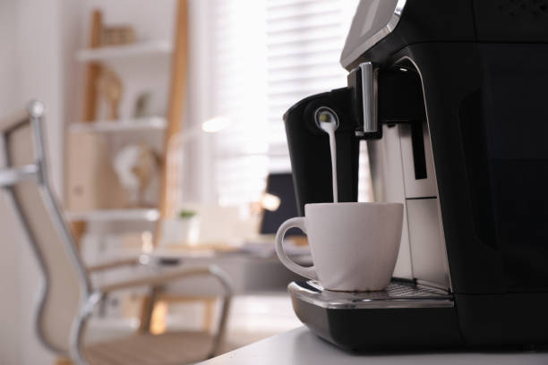 istock Modern coffee machine pouring milk into cup in office. Space for text 1433105041