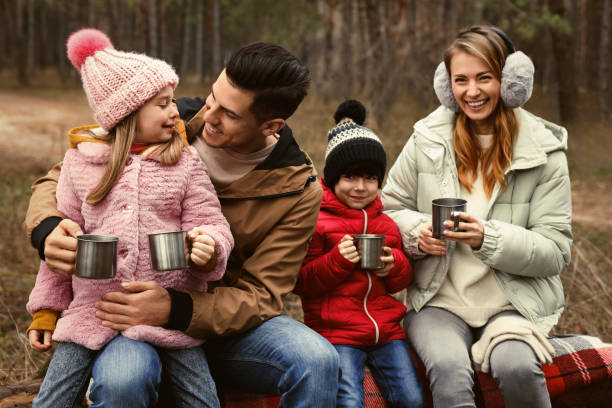 istock Happy family with hot drinks spending time together in forest 1433107798