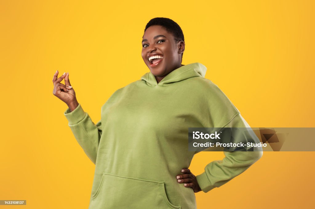 Joyful Overweight Black Woman Snapping Fingers Over Standing Yellow Background Joyful Overweight Black Woman Snapping Fingers Smiling To Camera Standing Posing Over Yellow Studio Background. It's Easy, Finger Clicking Gesture Concept Snapping Fingers Stock Photo