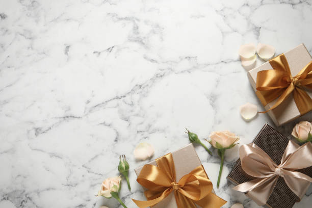 istock Gift boxes and beautiful roses on white marble background, flat lay. Space for text 1433108342