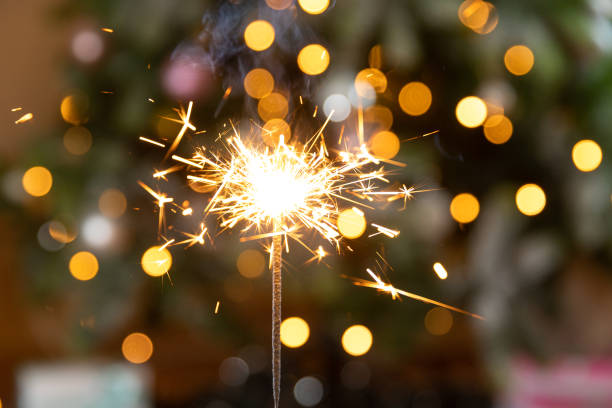 istock Christmas glittering sparklers candle burns in Christmas tree background. Xmas lighting decoration at home indoor. Festive Magic sparks lights for holiday party. Christmas eve with fireworks. 1433109773