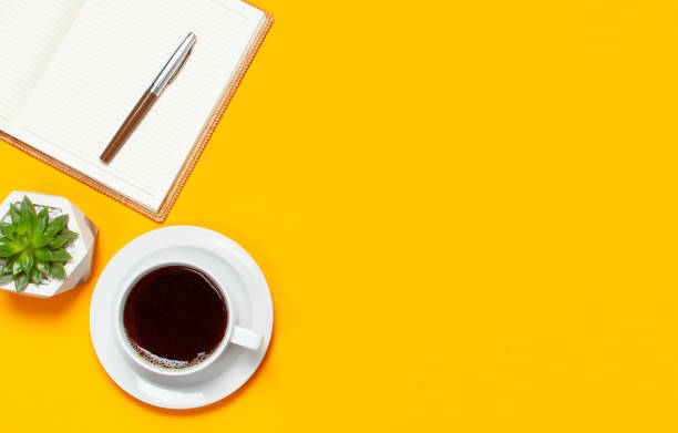 istock Cup of coffee, open notebook with blank pages, pen, cactuses succulents on bright yellow minimalistic background top view Flat Lay with copy space. Still life, business, office, education concept 1433110450