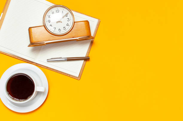 istock Cup of coffee, open notebook with blank pages, retro alarm clock, pen, cactuses succulents on bright yellow minimalistic background top view Flat Lay with copy space. Still life, concept of business lunch 1433110467