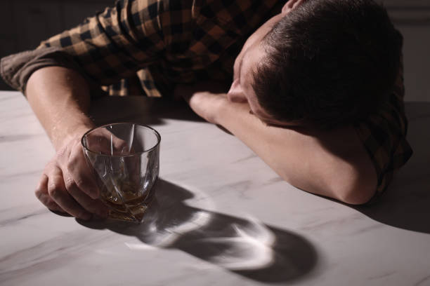 istock Addicted man with alcoholic drink sleeping at table in kitchen, closeup 1433110590