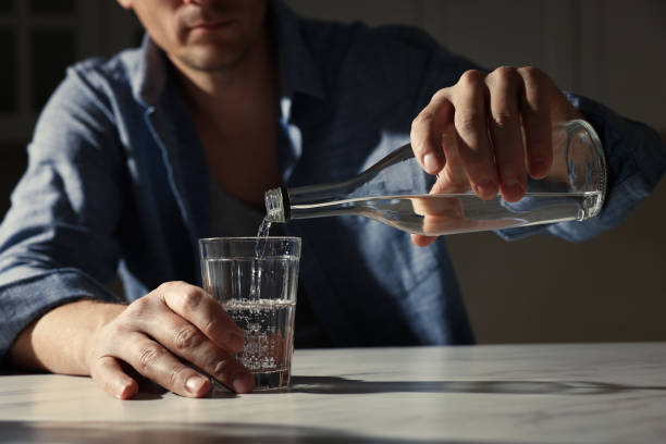 istock Addicted man with alcoholic drink at table in kitchen, closeup 1433110652