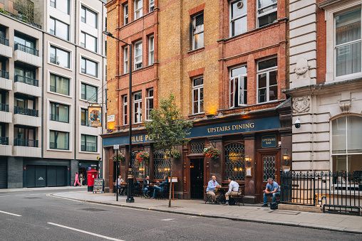London, UK - September 1, 2022: People at the outdoor tables of The Blue Posts pub on Newman Street in Fitzrovia, diverse area of Central London dotted with restaurants, hotels, pubs and galleries.
