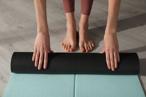 istock Woman rolling yoga mat on floor, closeup 1433112864