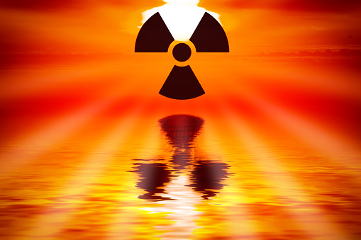 radioactive symbol over the water with skull in the reflection