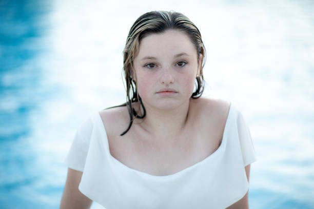 Portrait of a young woman looking at camera while remaining wet after getting out of a pool