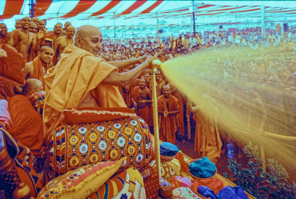 Pramukh Swami Maharaj spraying Holi Festival coloured water stock photo