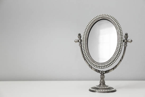 istock Stylish round mirror on table near white wall, space for text 1433114875