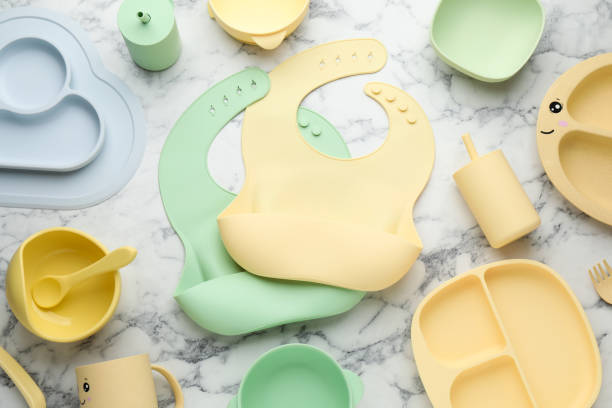 istock Flat lay composition with silicone baby bibs and plastic dishware on white marble background 1433116655