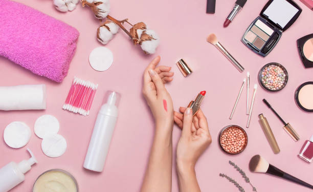 Make-up Remover Accessories. Flat lay background Womens hands try cosmetics, cotton branch, cotton pads, cosmetic bottle containers, pink towel, various make-up cosmetics, mascara, powder, lipstick, eyeshadow accesorios desmaquillantes. fondo plano las manos de las mujeres prueban cosméticos, rama de algodón, almohadillas de algodón, recipientes de botellas de cosméticos, toalla rosa, varios cosméticos de maquillaje, rímel, polvo, lápiz labial, sombra de