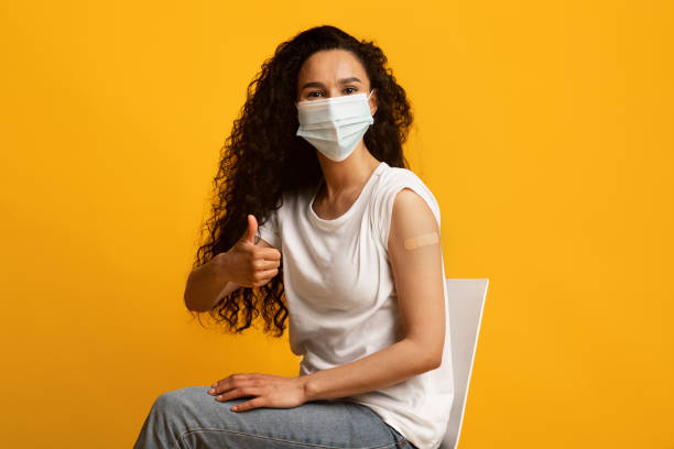 istock Covid-19 Vaccination. Vaccinated Brunette Lady With Plaster On Arm Showing Thumb Up 1433119372