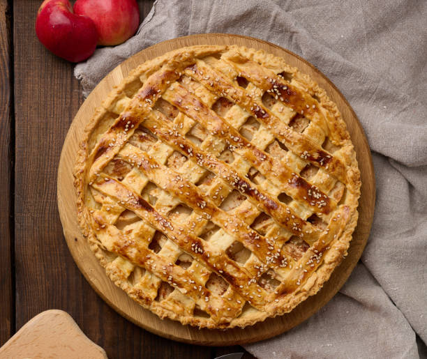istock Round baked apple pie on a brown wooden table, top view 1433122376