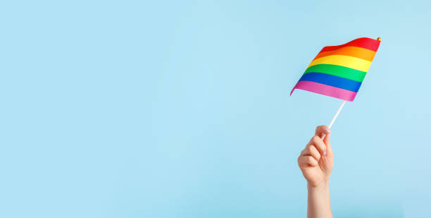 istock Gay flags in women's hand on grey background 1433123886