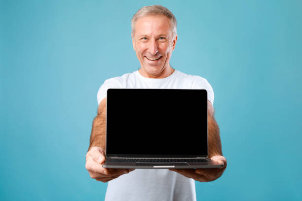 istock Happy mature man showing black empty laptop screen 1433124293