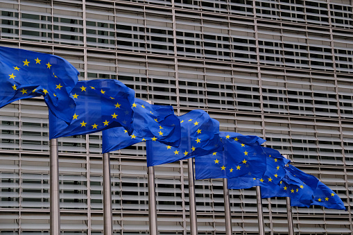 European flags flap in the wind outside EU headquarters in Brussels, Belgium on July 21st, 2022