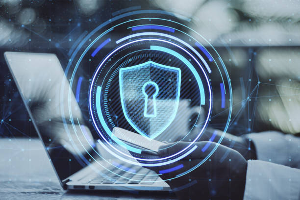 istock Close up of male hands using smartphone and laptop on desktop with creative glowing blue shield hologram on blurry background. Secure, safety, database and web protection concept. Double exposure. 1433126003