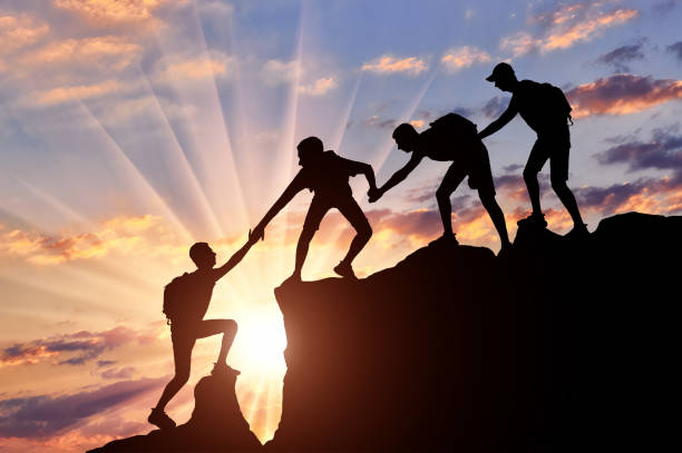 istock Men climbers help each other in the mountains 1433126425