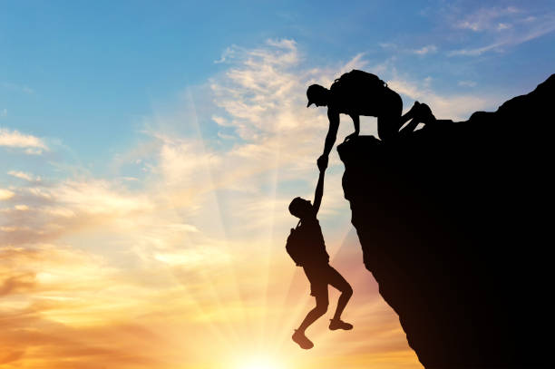 istock Silhouette of a climber saves another climber pulling him from the abyss 1433126437