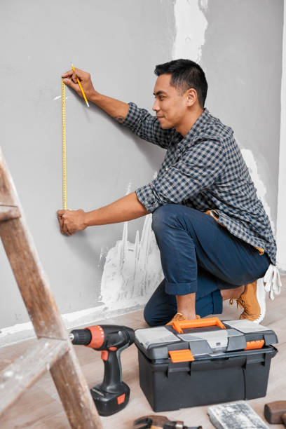 istock An Asian man measures against the wall using measuring tape doing home DIY 1433127451