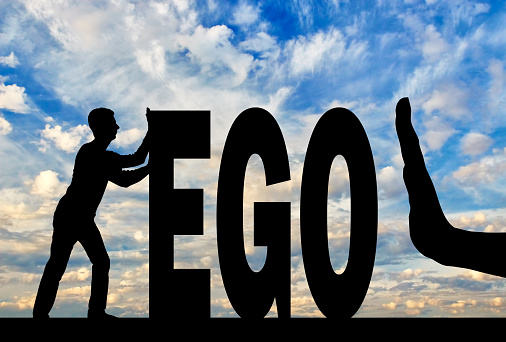 Gesture of the hand stop and silhouette of the man pushing the word ego. The concept of egoism as a problem in society