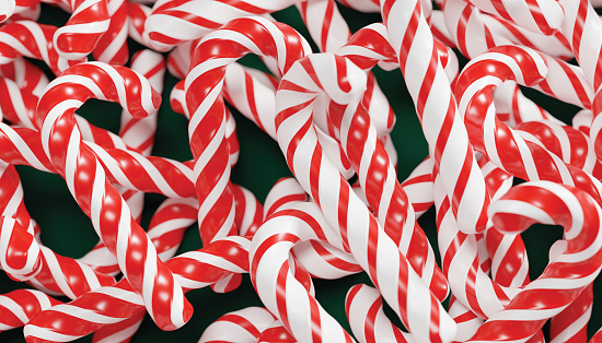 Festive candy cane hanging on a tree branch.