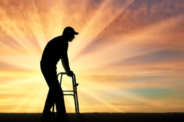 istock Silhouette of a disabled man walking, using a walker for the disabled 1433132449