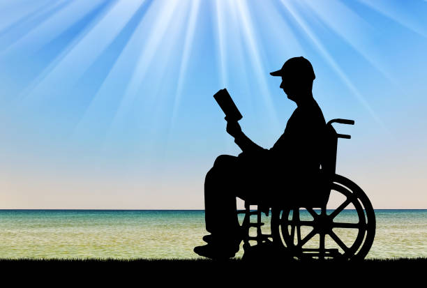 silueta de un hombre discapacitado en silla de ruedas leyendo un libro - outdoors book reading accessibility fotografías e imágenes de stock