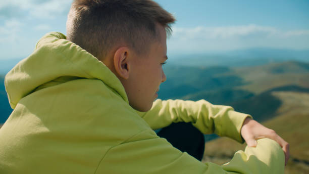 istock Young guy sitting on stone and watching on landscape 1433133261
