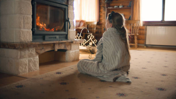 istock Young girl sitting by the fireplace 1433134269
