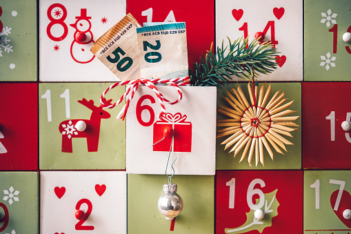 Wooden calendar, Christmas Eve, 24th December with candle, pine cones and red stars