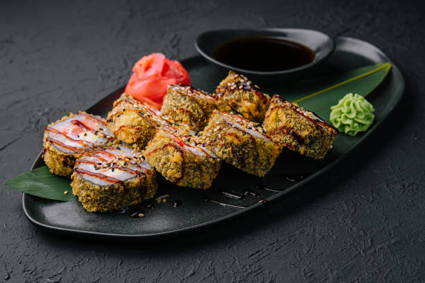 istock Served warm sushi with ginger and wasabi on a black stone plate 1433137194