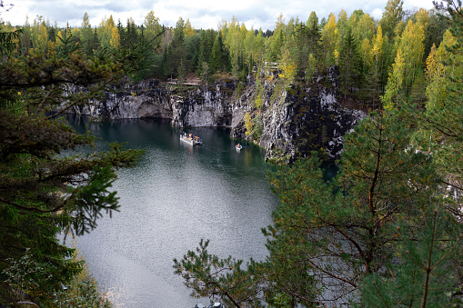boats floating on the lake in the marble canyon surrounded by autumn forest.