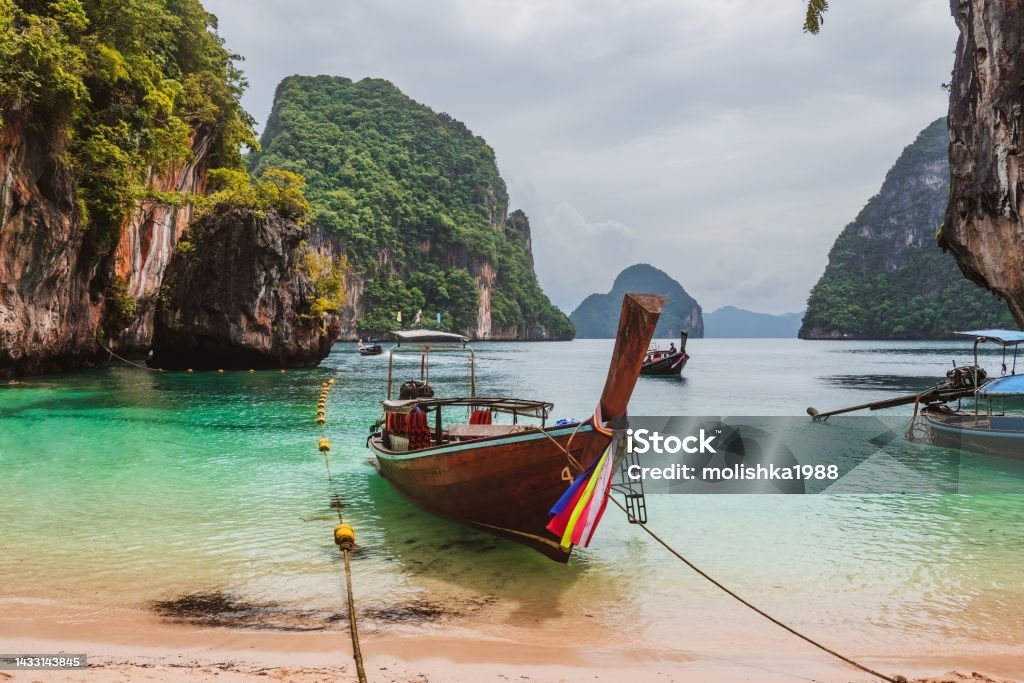 Long tail tourist boats on sea shore near Koh Hong island in Krabi province Trip in Thailand. Long tail tourist boats on sea shore near Koh Hong island in Krabi province. Tour in southern Thailand with beautiful nature, limestone cliffs. Adventure Stock Photo