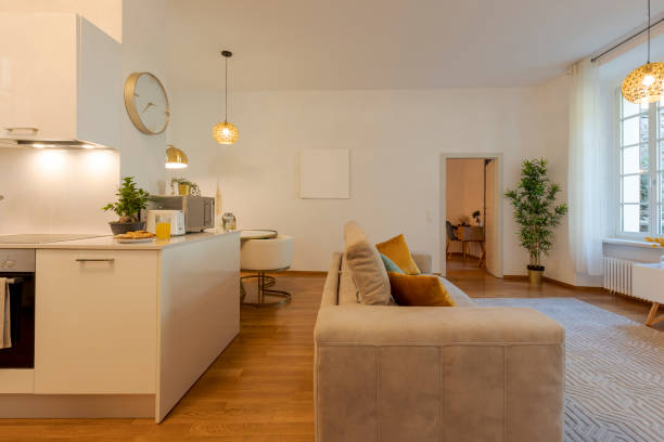 istock Modern open space in elegant apartment. There is the kitchen with breakfast ready to be tasted, a sofa and large bright windows 1433143959