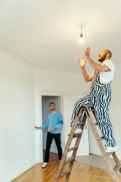 istock Man looking excited after fixing a broken light at a house 1433147139
