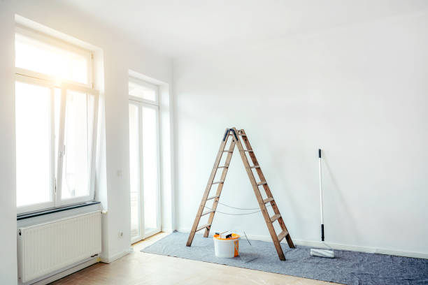 Renovate living room with color bucket and ladder Empty apartment after renovation. Painting in a white room with windows with a stepladder, paint roller and paints on the floor. restoring home improvement house home interior stock pictures, royalty-free photos & images