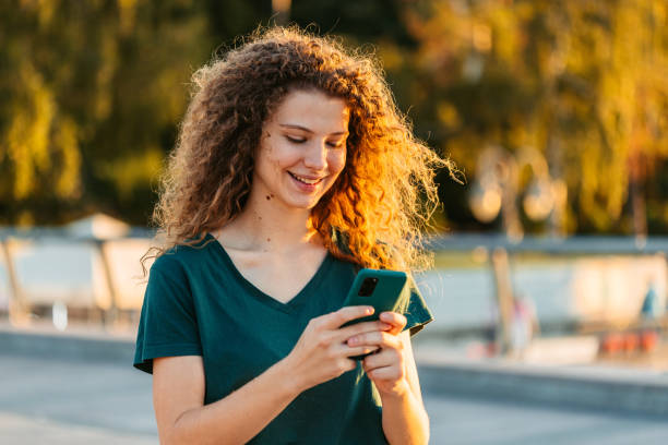 istock Young Woman Using Phone While Walking Down The Street 1433151160