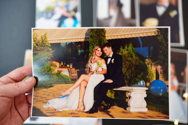 istock printed wedding photos on a black background and in hand. 1433151173