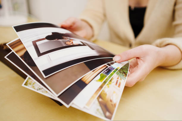 printed wedding photos in the women hands. printed wedding photos in the printed wedding photos in the women hands. the concept of preserving the memory of an important event, the services of a professional photographer for the celebration. wooden flash drive stock pictures, royalty-free photos & images