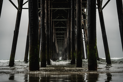 A Dramatic Shot of a Pier Off of the Coast of California, A dark and gloomy day near a pier in southern California.