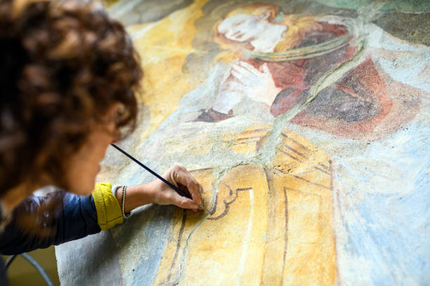 professional restorer restoring antique chapel fresco in italy - restoring art painting artist imagens e fotografias de stock